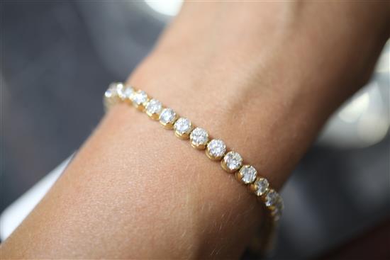 An 18ct gold and diamond line bracelet, 18cm.
